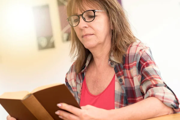 Donna matura che legge un libro, effetto luce — Foto Stock