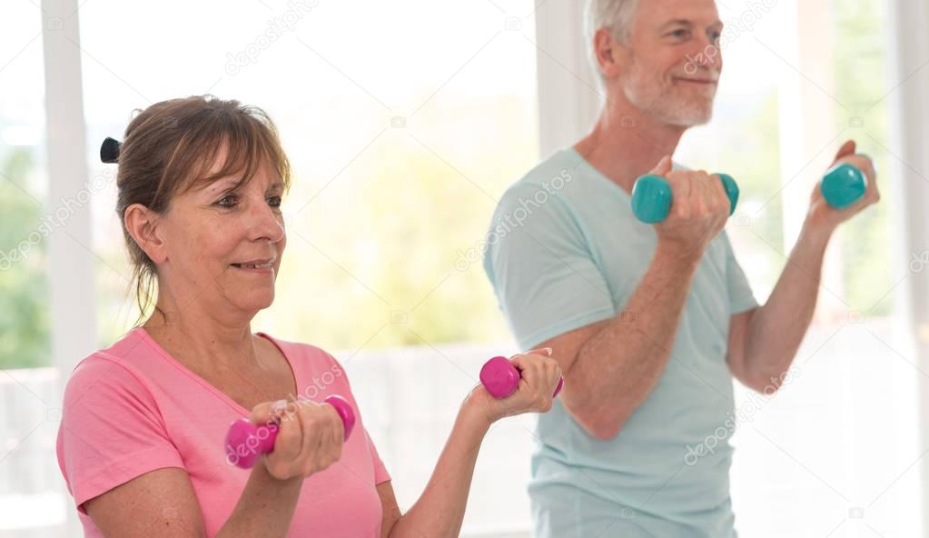 Senior couple exercising with dumbbells
