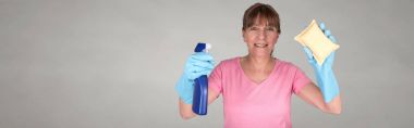 Bir sünger ve sprey Temizleme windows kullanarak ev kadını