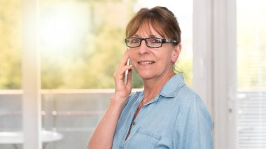 Olgun kadın üstünde hareket eden telefon, ışık etkisi söz