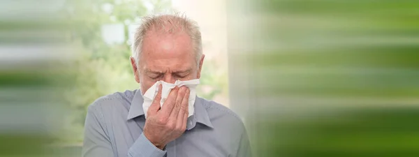 Senior man blowing his nose — Stock Photo, Image