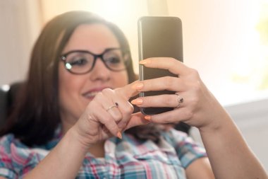 Cep telefonu, ışık efekti kullanan genç kadın