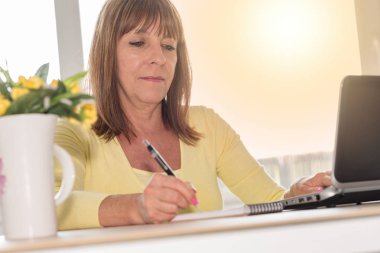 Not alma ve dizüstü bilgisayar, ışık efekti çalışan kadın