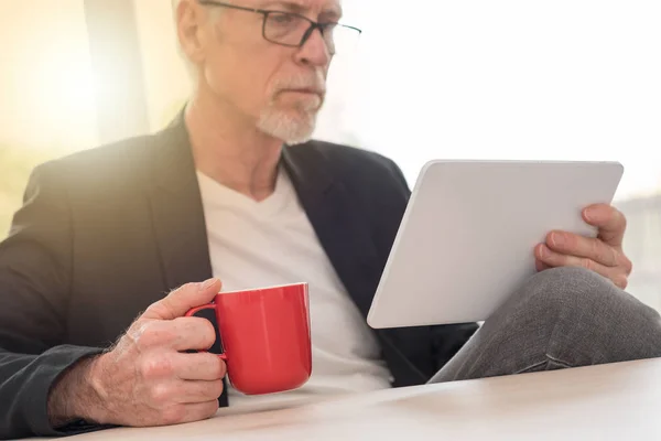 Senior man using his tablet, light effect