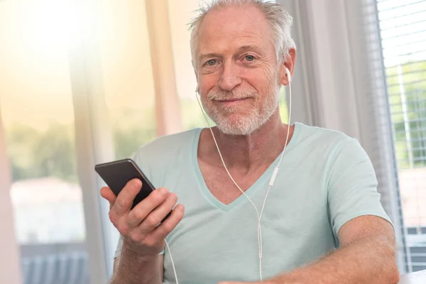 Portret van een volwassen man luisteren muziek met koptelefoon, lichte EVF — Stockfoto