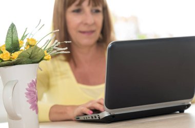 Evde Dizüstü bilgisayar kullanan kadın