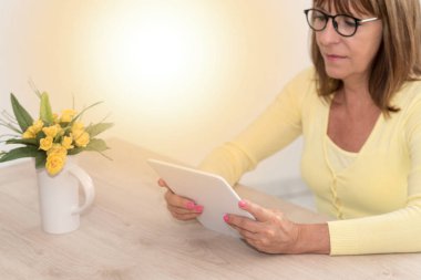 Evde, bir tablet kullanan kadın ıșık etkisi