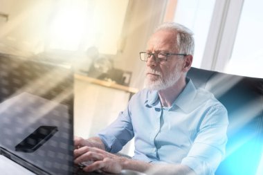 Dizüstü bilgisayar, ışık efekti çalışan üst düzey işadamı portresi