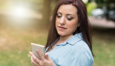 Onun cep telefonu, ışık efekti kullanan genç kadın portresi