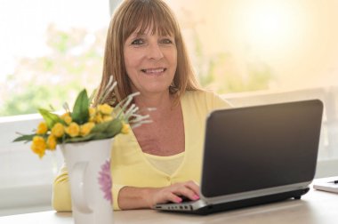 Evde, dizüstü bilgisayar kullanan kadın ışık efekti portresi