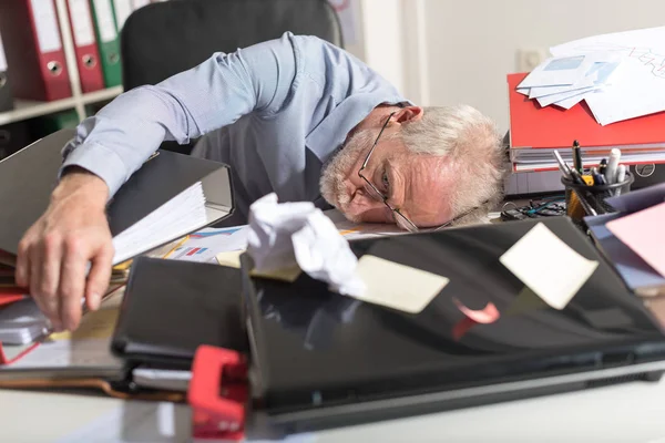 Überlasteter Geschäftsmann schläft auf unordentlichem Schreibtisch — Stockfoto