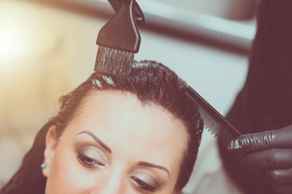 Hairdresser coloring hair, light effect