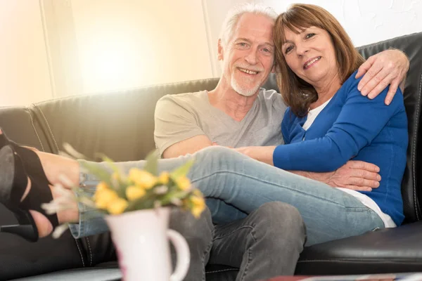 Lyckliga senior paret sitter på soffan och omfamna varje annat, li — Stockfoto