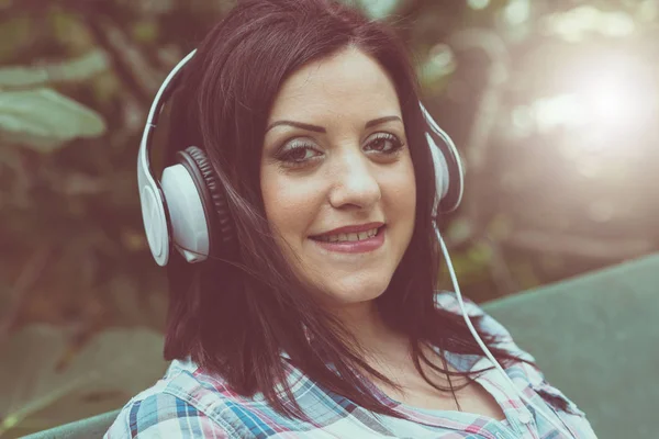 Mulher bonita ouvindo música com fones de ouvido, eff luz — Fotografia de Stock