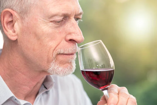 Uomo maturo degustazione vino rosso, effetto luce — Foto Stock