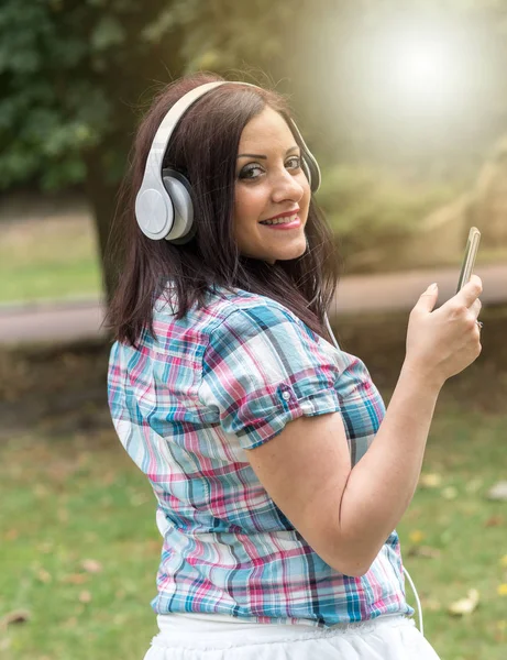 Mulher bonita ouvindo música com fones de ouvido, eff luz — Fotografia de Stock