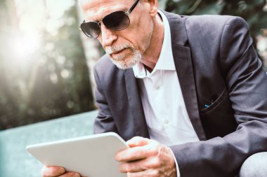 Olgun adam ışık efekti açık havada, onun tablet kullanma