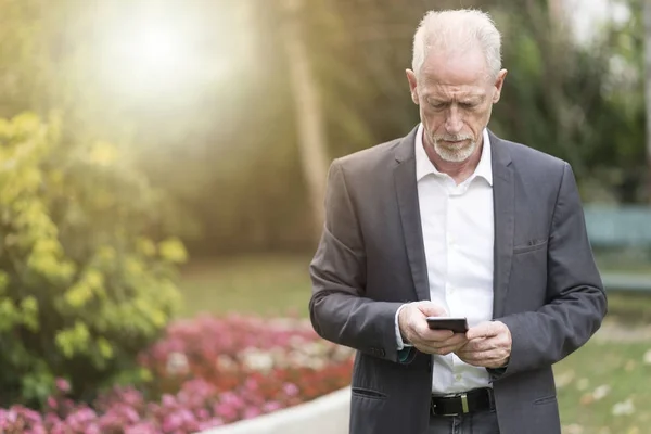 Volwassen man met zijn mobiele telefoon, lichteffect — Stockfoto