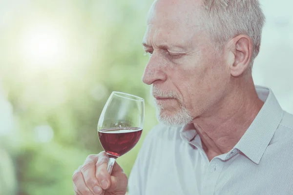 Uomo maturo degustazione vino rosso, effetto luce — Foto Stock