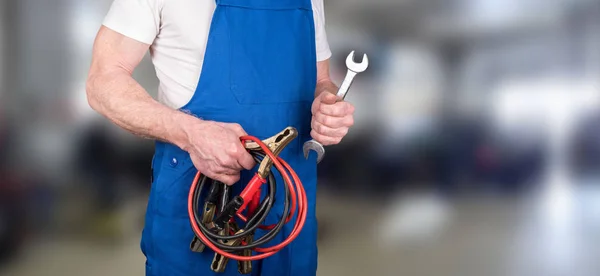 Kfz-Mechaniker hält Sprungleine und Schraubenschlüssel — Stockfoto