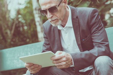 Olgun adam açık havada onun tablet kullanma