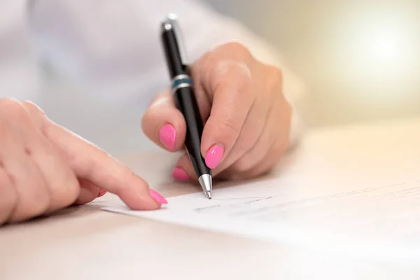 Femme signant un contrat, effet de lumière — Photo