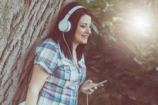 Genç ve güzel kadın kulaklık, ışık eff ile müzik dinlemek — Stok fotoğraf