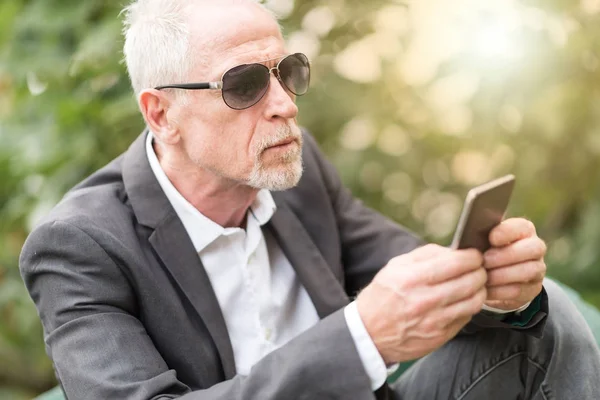 Volwassen man met zijn mobiele telefoon, lichteffect — Stockfoto