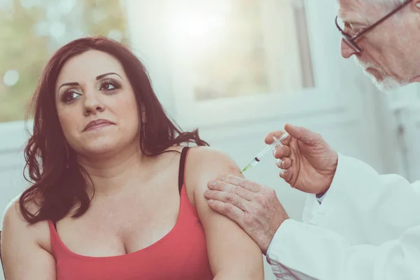Dokter menyuntikkan vaksin untuk wanita muda, efek cahaya — Stok Foto