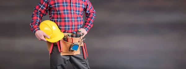 Byggnadsarbetare med verktygsbälte och hjälm — Stockfoto
