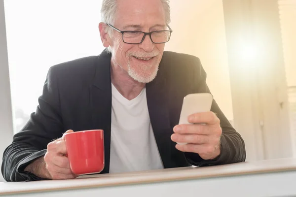 Senior man met zijn telefoon, lichteffect — Stockfoto