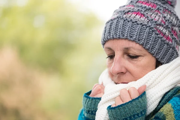 Woman being cold and holding her scarf against her mouth