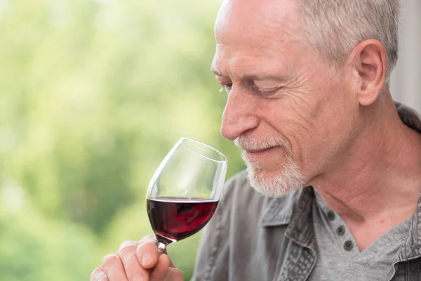 Uomo maturo degustazione vino rosso — Foto Stock