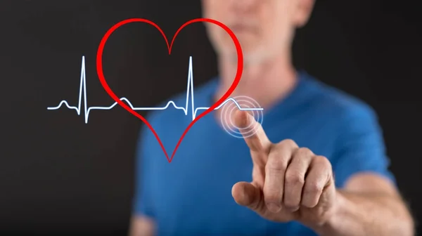 Człowiek, dotykając serce bije wykres na ekranie dotykowym — Zdjęcie stockowe