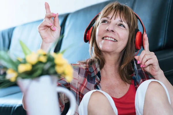 Mulher madura feliz ouvindo música — Fotografia de Stock