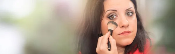 Beautiful woman applying cosmetic powder on her face — Stock Photo, Image