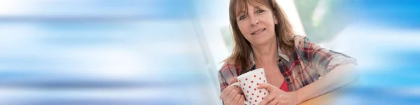 Porträt einer reifen Frau, die lächelt und einen Becher hält — Stockfoto