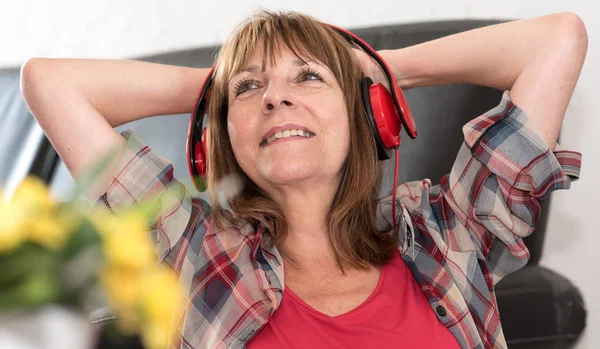 Mulher madura feliz ouvindo música — Fotografia de Stock