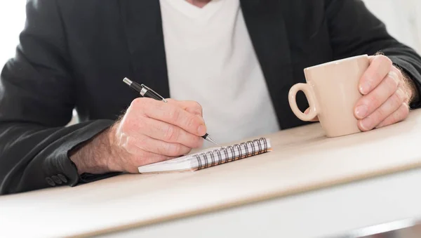 Hombre tomando la escritura en un cuaderno — Foto de Stock