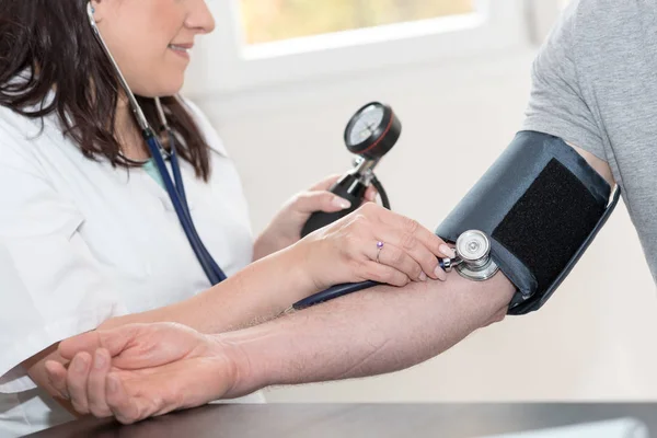 Médico que mede a pressão arterial — Fotografia de Stock