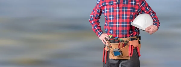 Building worker with tool belt and helmet — Stock Photo, Image