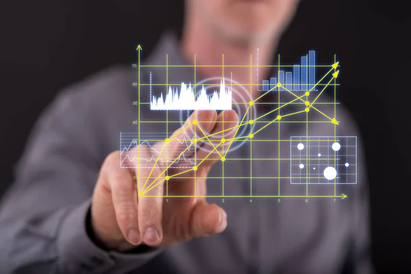 Hombre tocando gráficos de negocios en una pantalla táctil —  Fotos de Stock