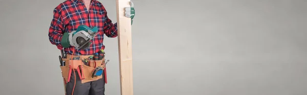 Building worker with tool belt and wood board