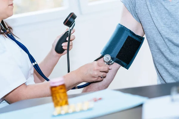 Médico que mede a pressão arterial — Fotografia de Stock