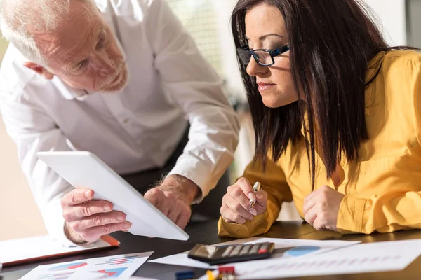 Young businesswoman and senior businessman working together — Stock Photo, Image