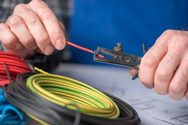 Eletricista descascar um fio — Fotografia de Stock