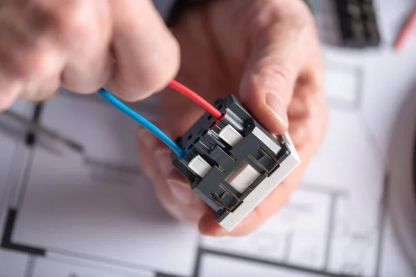 Electricista conectando un cable en una toma de corriente — Foto de Stock