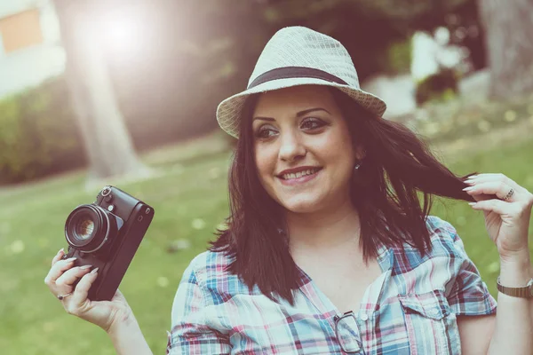 Belle jeune femme prenant des photos dans un parc, effet de lumière — Photo
