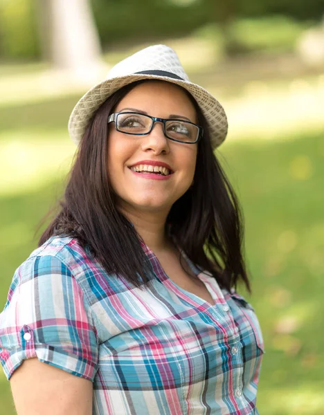 Ritratto di bella giovane donna con cappello in parco — Foto Stock