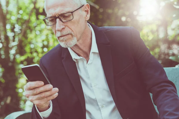 Volwassen man met zijn mobiele telefoon, lichteffect — Stockfoto